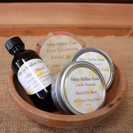 Wooden bowl holding a bottle and tins of facial skincare products