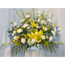 Large yellow and white floral arrangement on a pedestal