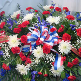 Red, white, and blue funeral spray with ribbon bow