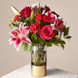 Mixed bouquet of pink roses and lilies in a glass vase