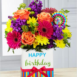 Colorful bouquet in a birthday gift box with a ribbon and card