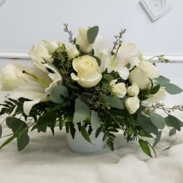 White roses and lilies arranged in a white vase
