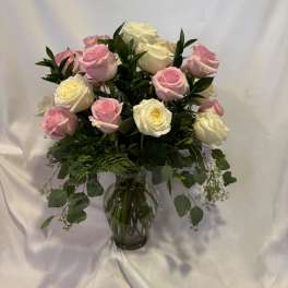 Pink and white roses arranged in a glass vase