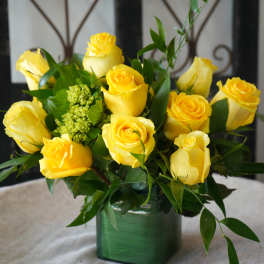 Yellow roses arranged in a green square vase