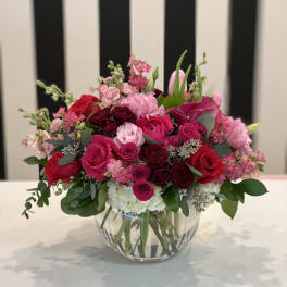 Pink and red rose arrangement in a clear glass vase