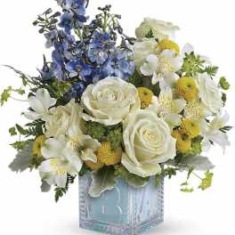 Blue and white floral arrangement in a clear square vase