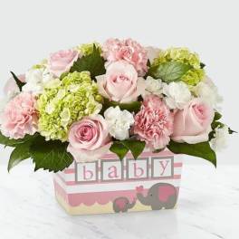 Pink roses and carnations in a baby-themed box