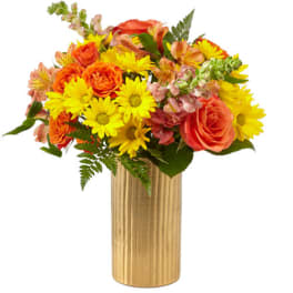 Orange roses and yellow daisies in a gold vase