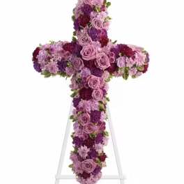 Purple and pink floral cross on a white stand