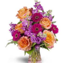 Bouquet of orange roses and purple daisies in a glass vase