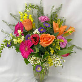 Mixed bouquet of colorful flowers in a clear glass vase