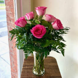 Pink roses arranged in a clear glass vase