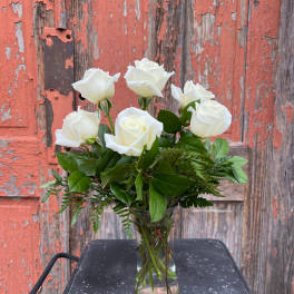White roses arranged in a clear glass vase