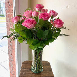Pink roses arranged in a clear glass vase