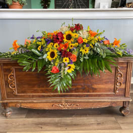 Large casket spray with sunflowers, roses, and lilies