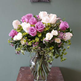 Pink and white roses arranged in a clear glass vase