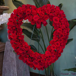 Heart-shaped arrangement of red roses on a stand