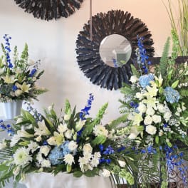 White and blue floral arrangements with lilies and roses in vases
