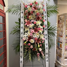 Tall standing floral wreath with pink and white flowers and Korean condolence ribbons
