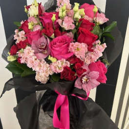 Bouquet of pink and red roses with orchids wrapped in black paper