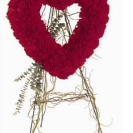 Red floral heart-shaped wreath on a stand