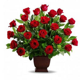 Red roses arranged in a brown urn vase