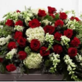 Red roses and white flowers arranged on a casket