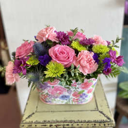 Pink and purple mixed flower arrangement in a floral box