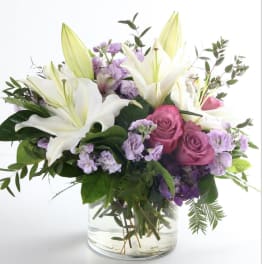 Bouquet of white lilies and pink roses in a clear glass vase