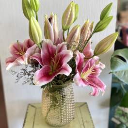 Pink lilies arranged in a textured glass vase