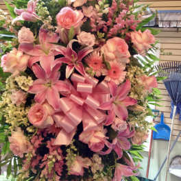 Large pink floral standing spray with a satin bow