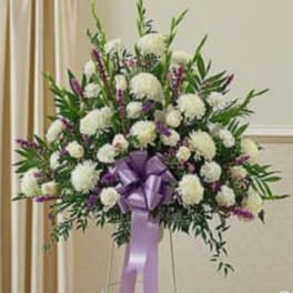 Large white and purple floral standing spray with a lavender ribbon