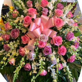 Large bouquet of pink and lavender roses with white orchids and a pink ribbon