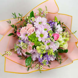 Bouquet of pink, lavender, and white flowers wrapped in pink paper