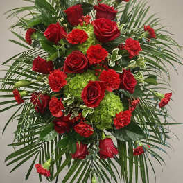 Standing floral spray with red roses and carnations on a tripod easel