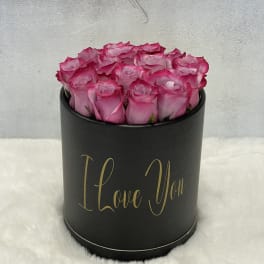 Round black hat box filled with pink roses and gold I Love You text on the front