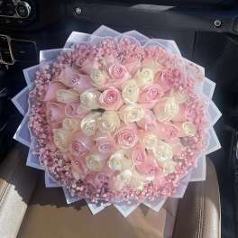 Round bouquet of pink and white roses with pink filler flowers
