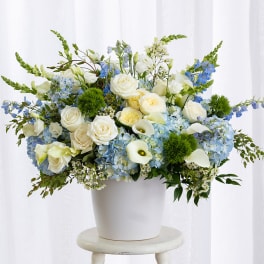Blue and white floral arrangement in a white pot