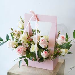 Pink gift box with pale roses and ribbon