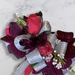 Boutonniere with pink and burgundy roses and silver ribbon