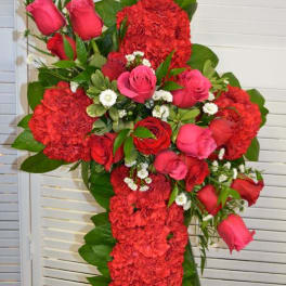 Red and pink floral standing spray on a cross-shaped easel