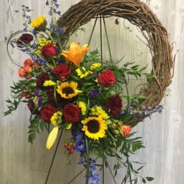 Colorful floral wreath on a stand with roses and sunflowers