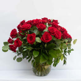 Red roses arranged in a clear glass vase