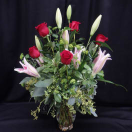 Bouquet of red roses and pink lilies in a glass vase