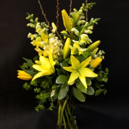 Yellow lilies and snapdragons in a clear glass vase