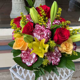 Bouquet of red and peach roses with yellow lilies and carnations