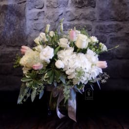 White and blush floral arrangement in a glass vase