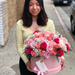Woman holding a large pink box of mixed roses