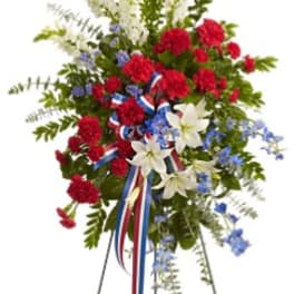 Standing floral spray with red, white, and blue flowers on an easel