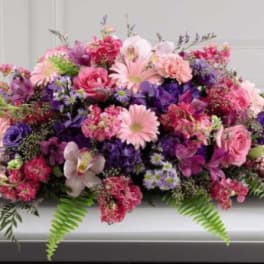 Pink and purple floral casket spray with mixed blooms